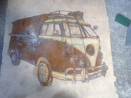 A handcrafted plasma-cut steel wall art piece depicting a vintage split-screen VW camper pickup van with a canvas canopy, finished with a rustic rust patina and cream accents.