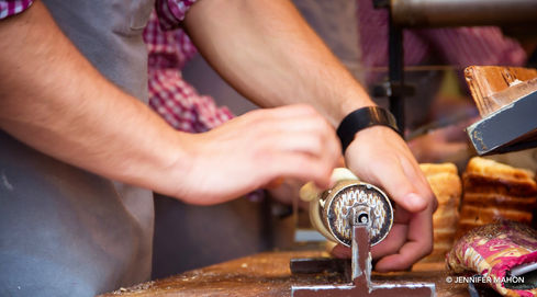 Rolling a traditional pastry called Trdelnik