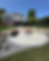 Flagstone patio with fire pit and chairs behind a house