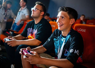 2 Jungs sitzen im Kinosaal und halten Controller in der Hand