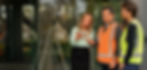 Katy founder looking at ipad with two warehouse workers standing in front of worksite