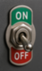 a silver switch pointing toward a red label marked 'off' and facing away from a green label marked 'on'