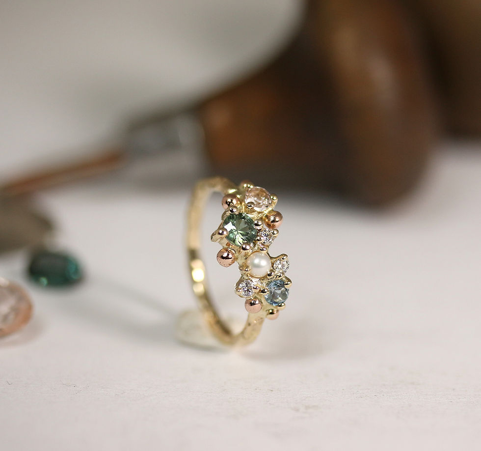Thumbnail: Sleek structured gold ring with various gemstones