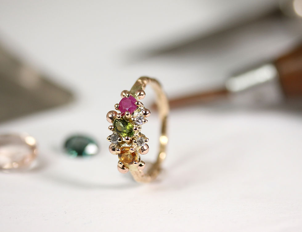 yellow gold ring with different gemstones.