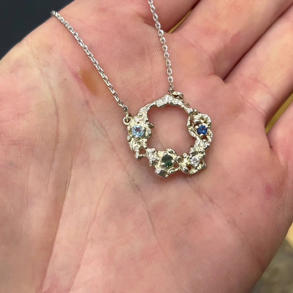 Thumbnail: Unique white gold necklace with free form round pendant in a hand