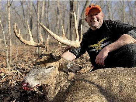 man smiling holding buck