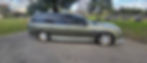 Green hearse parked in a cemetery