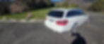 White Mercedes-Benz station wagon parked by a memorial garden