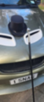 Top hat and cane on the hood of a car