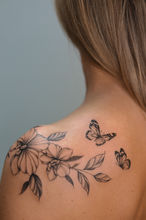 woman back tattoo fineline flowers florals orchids butterflies delicate feminine