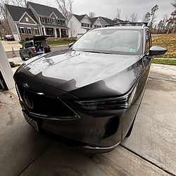 Gray Acura SUV parked in a driveway in front of a house.