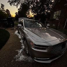 Shiny silver car parked, open hood, washing with sunset background