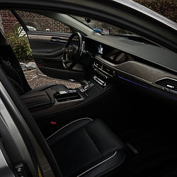 Interior view of a luxury car with black leather seats and dashboard.