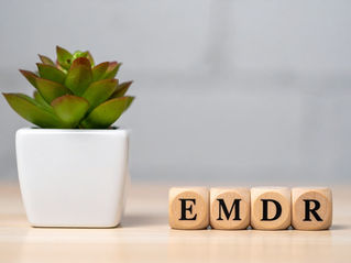 Scrabble letters spelling "EMDR" next to a plant