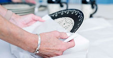 woman unpacking a plate after moving with settling in services from Architects of Moving