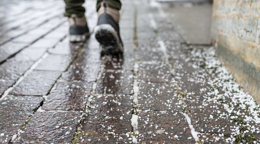 elderly man boots walking in a salt and snowy walkway outside accessible home in knoxville