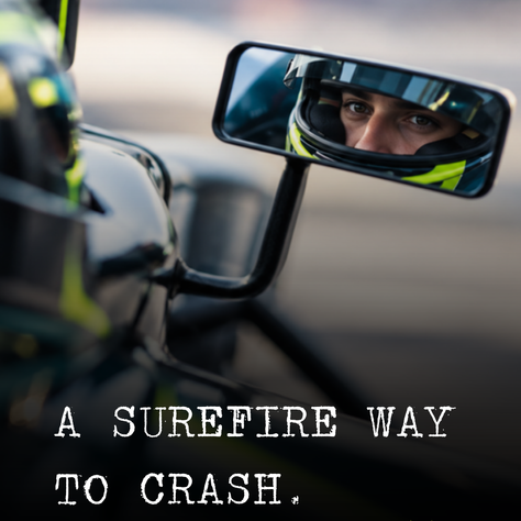 Race car driver staring into his side mirror