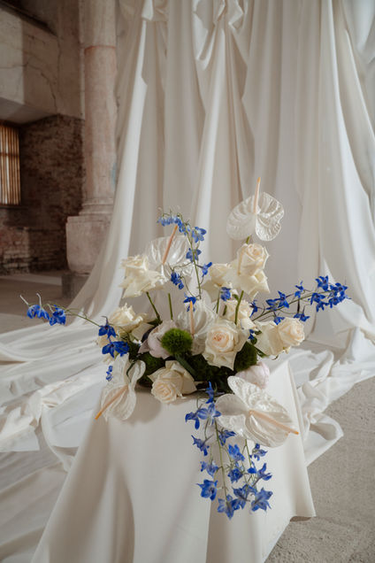 White flowers and blue accents styled against soft fabric