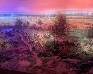 A dramatic section of the Cyclorama painting featuring fallen soldiers and debris under hazy, pink-toned battle smoke.