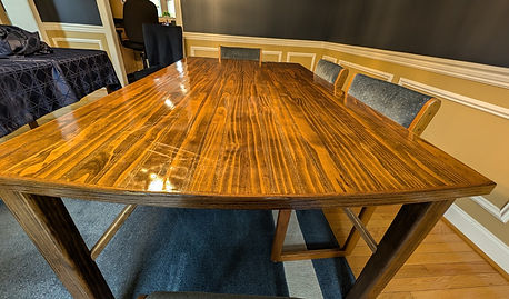 End view of a dining room table made from many small poplar boards.