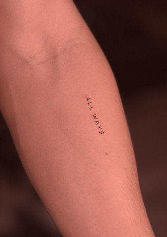 Tatuagem de palavra pequena em estilo fineline no braço
