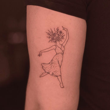 Tatuagem de uma mulher com flor conceitual em estilo fineline no braço