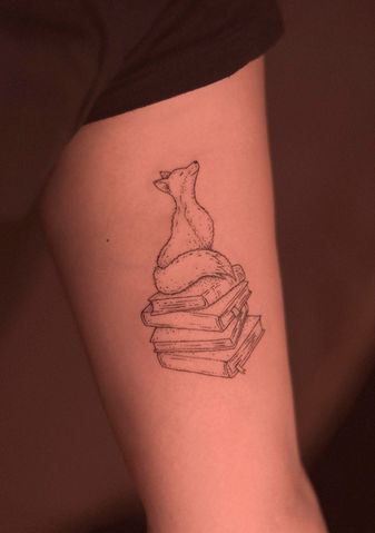Tatuagem de raposa e livros delicada em fineline