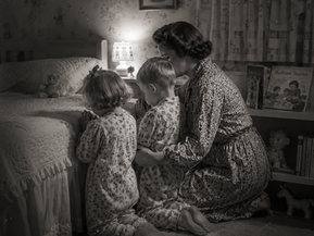 Timeless image of mother praying with children before bed