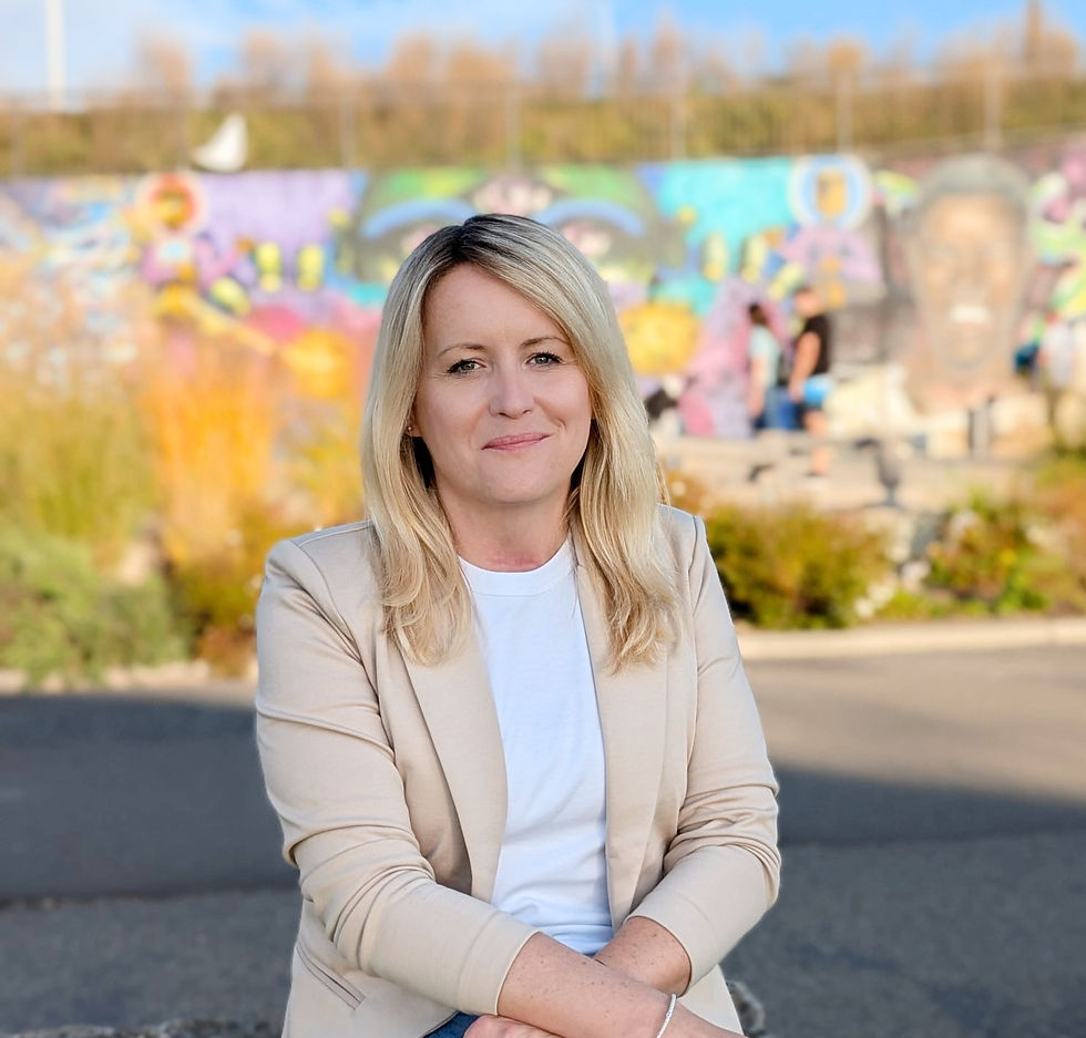 Alexandra Pisek, systemische Beraterin (DGSF) und Trainerin für Resilienz und mentale Gesundheit, sitzt lächelnd vor einer farbigen Graffiti-Wand.