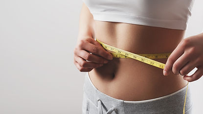 Close up of slim woman measuring her waist's size with tape measure .jpg