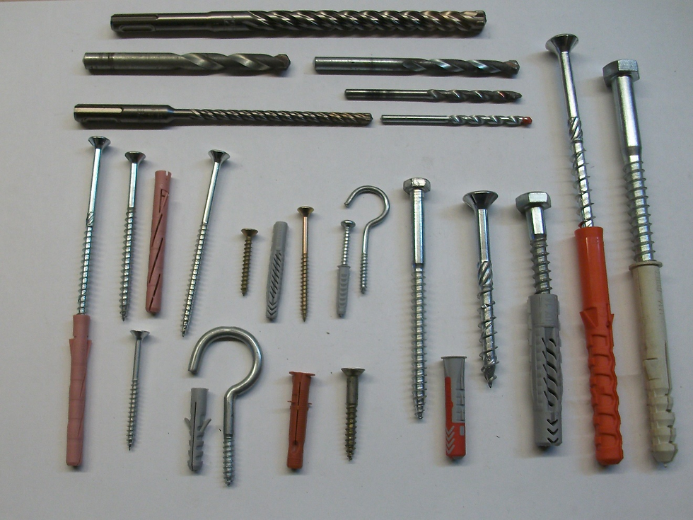 Eine Sammlung verschiedener Bohrer, Schrauben und Dübel auf weißem Hintergrund, die für unterschiedliche Handwerksprojekte geeignet sind.