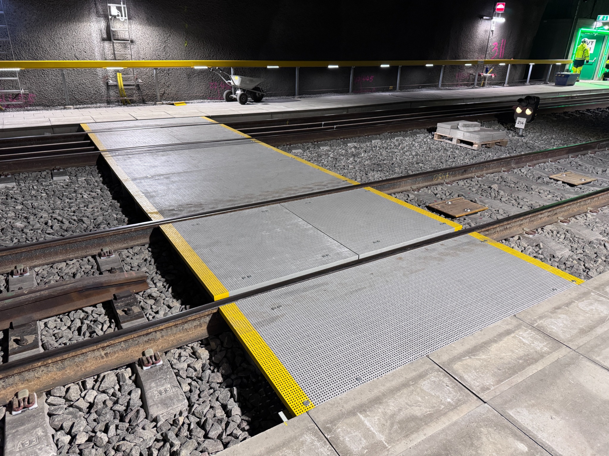 Transition of grating with yellow edge markings over the railway tracks in Varberg's new train tunnel