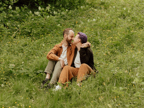 Queer couple Ryleigh & Gabe holding hands and touching noses in a field during their Saanich Gorge Park couples session in Victoria BC