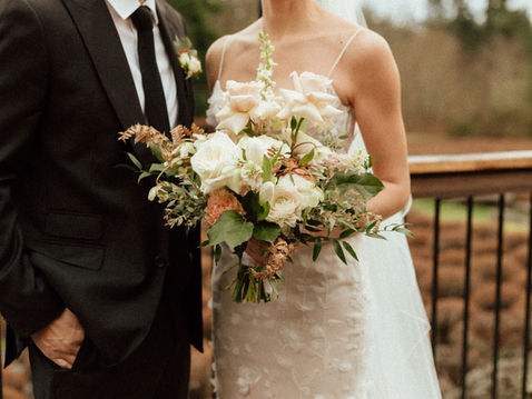 Wedding bouquet detail with Hazel and Sebastian standing together at Bilston Creek Farm