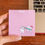Thumbnail: Hand holding a pink notepad of a tooth brushing another tooth.