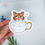 Thumbnail: Hand holding a sticker of an orange cat taking a bubble bath in a mug