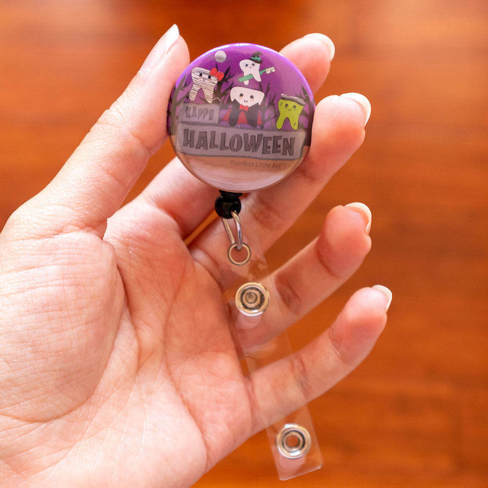 Hand holding a halloween dental themed badge reel