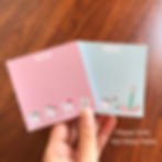 Hand holding two dental themed notepads