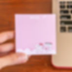 Hand holding a pink dental themed notepad