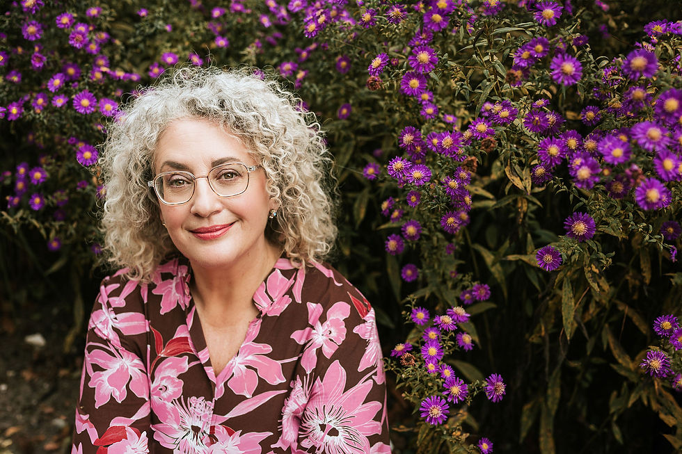 Smiling woman with curly hair, purple flowers