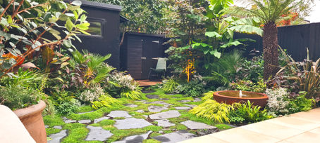A Small, Secluded City Garden with Tropical Planting and Stunning Water Feature