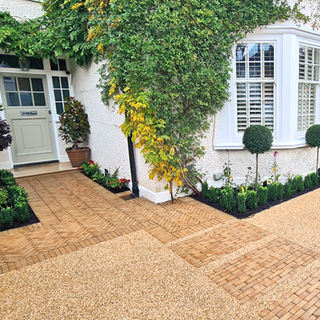 Front window borders with clipped bay trees