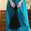Thumbnail: Close-up of black velvet wristlet held against teal satin trousers for a statement evening look.