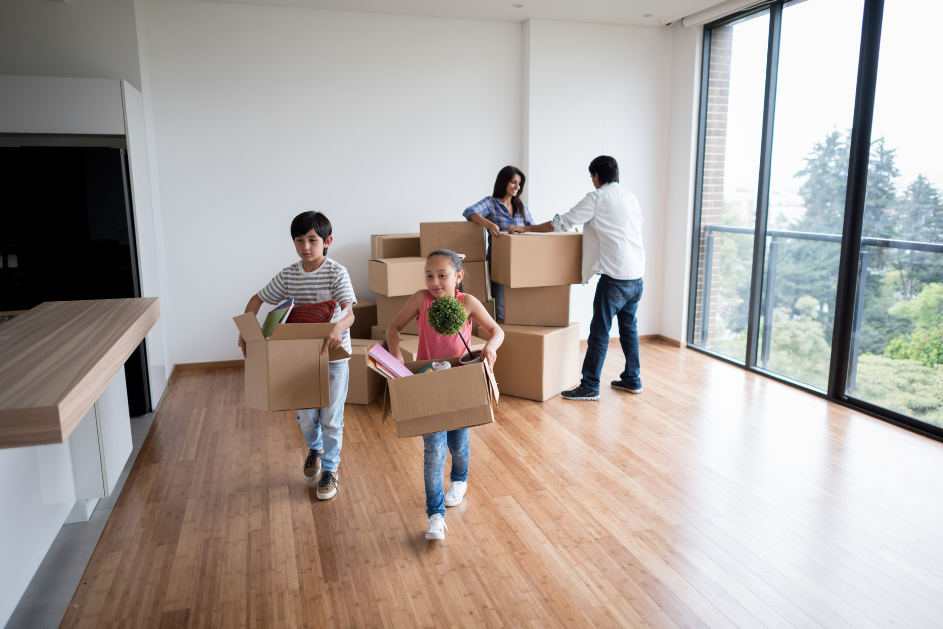 Family Unpacking Moving Boxes in Apartment