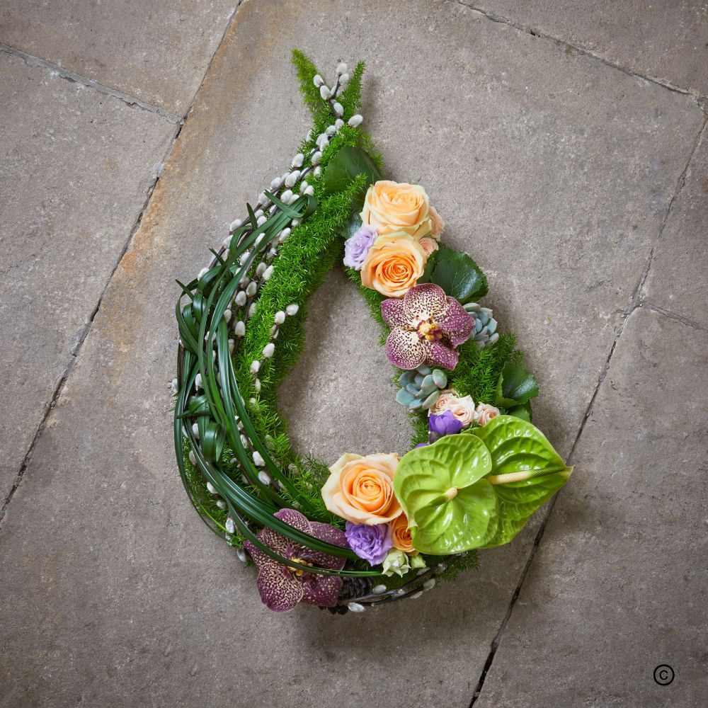 Modern Chaplet funeral flower tribute in peaches and greens