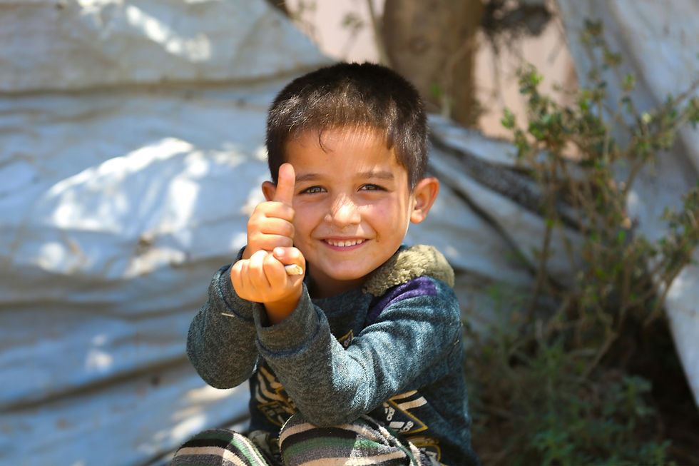 Photo of a refugee boy giving Life for Relief and Development (LIFE) a thumbs up.