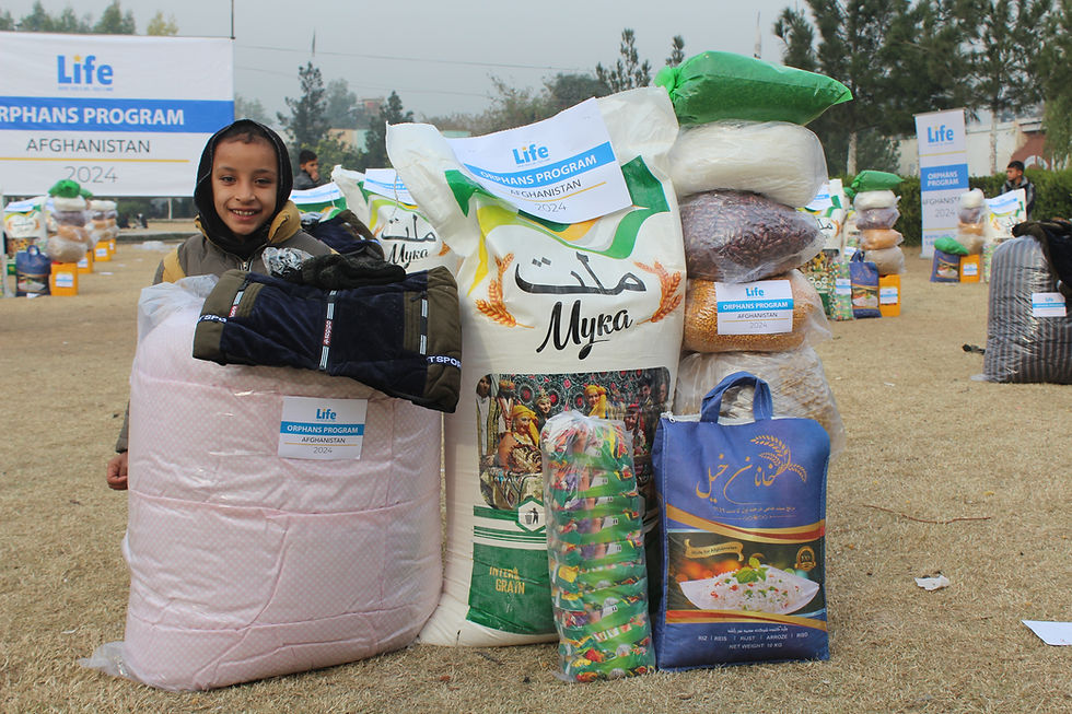Photo of a young orphan girl receiving a food basket and essentials from Life for Relief and Development USA (LIFE).