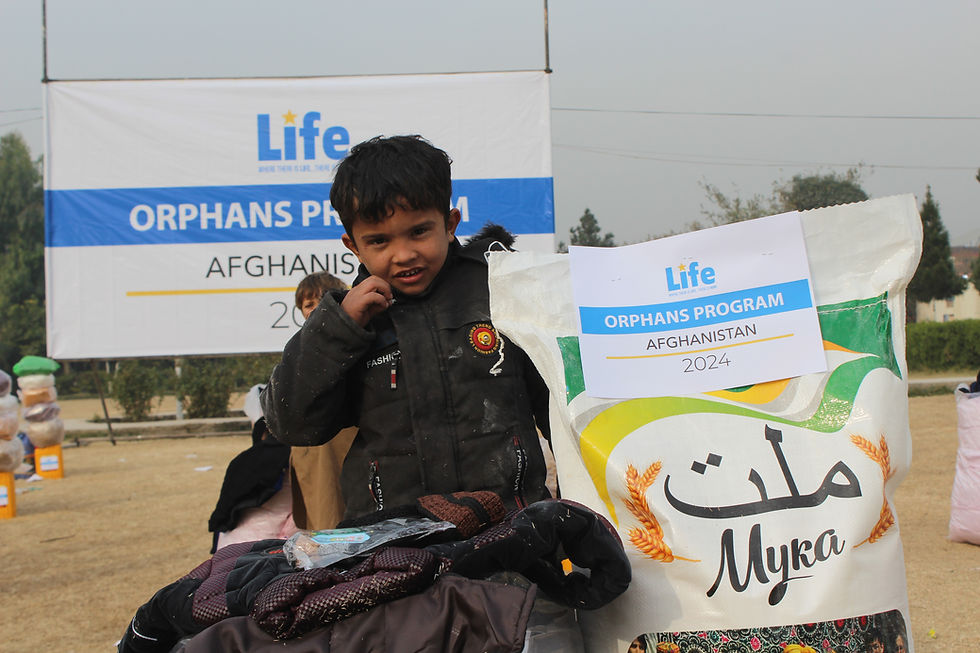 Photo of a young orphan boy receiving a food basket and essentials from Life for Relief and Development USA (LIFE).