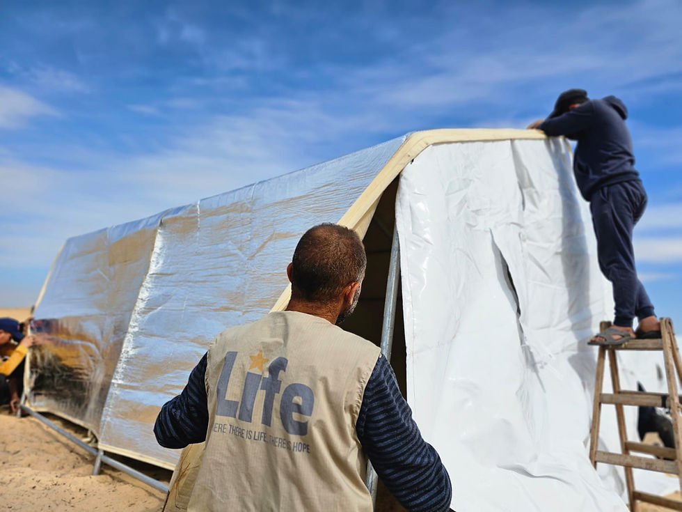 Photo of a Life for Relief and Development (LIFE) team member constructing tents for displaced persons in Gaza.