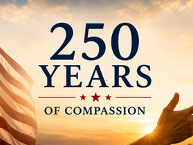 Hands reaching out in unity beneath the American flag, symbolizing 250 years of compassion and solidarity.